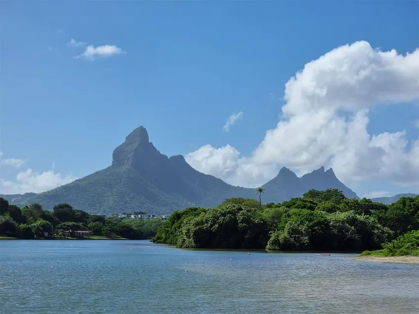 Capture of Mauritius' iconic mountains and lagoon under clear blue sky.