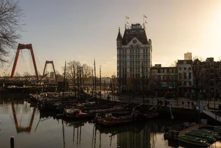 Dramatic sunset view of Willemsbrug and the historic White House building in Rotterdam, Netherlands.
