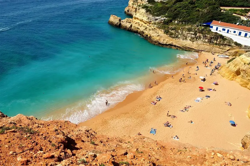 High-angle view of a sunny beach with people enjoying the summer sun and sea.