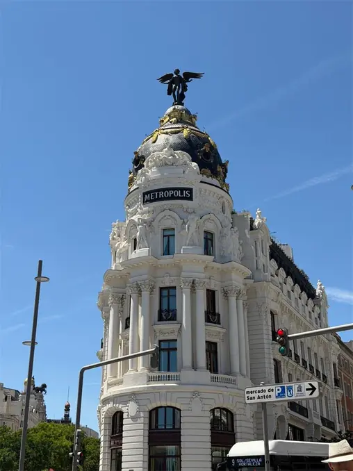 The iconic Metropolis Building in Madrid, Spain, captured on a sunny day with a blue sky.