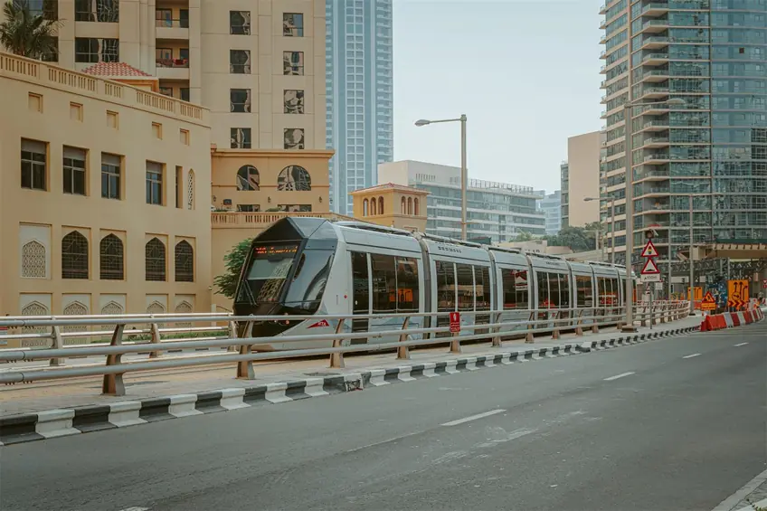 High speed subway moving above ground along high skyscrapers and residential houses in modern town